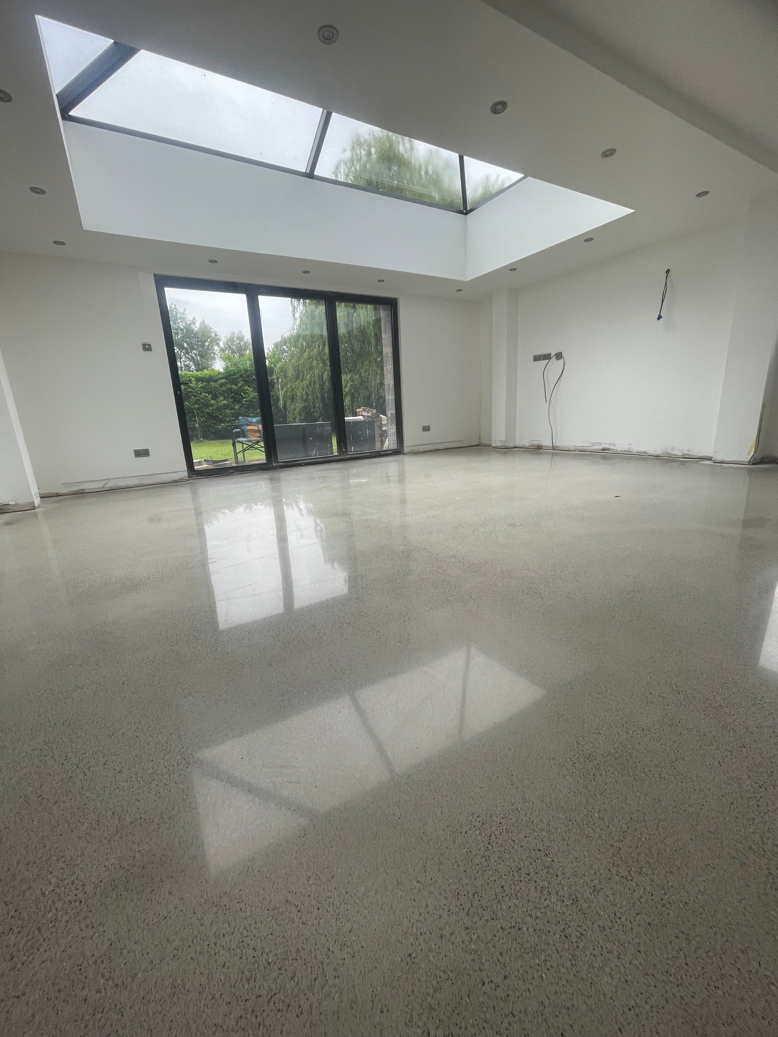 Polished concrete overlay in living room with log burner
