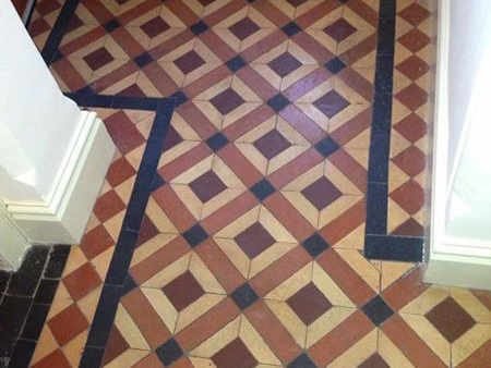 Victorian tile floor before restoration - stained grout and worn tiles