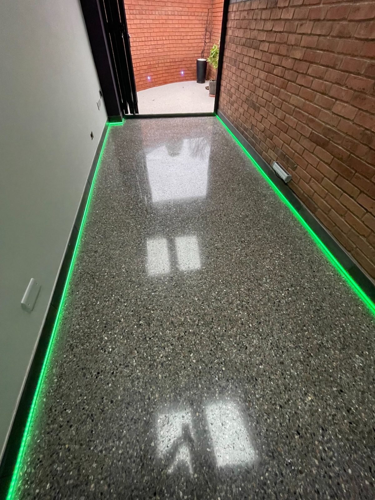 Pewter grey full aggregate high gloss polished concrete hallway