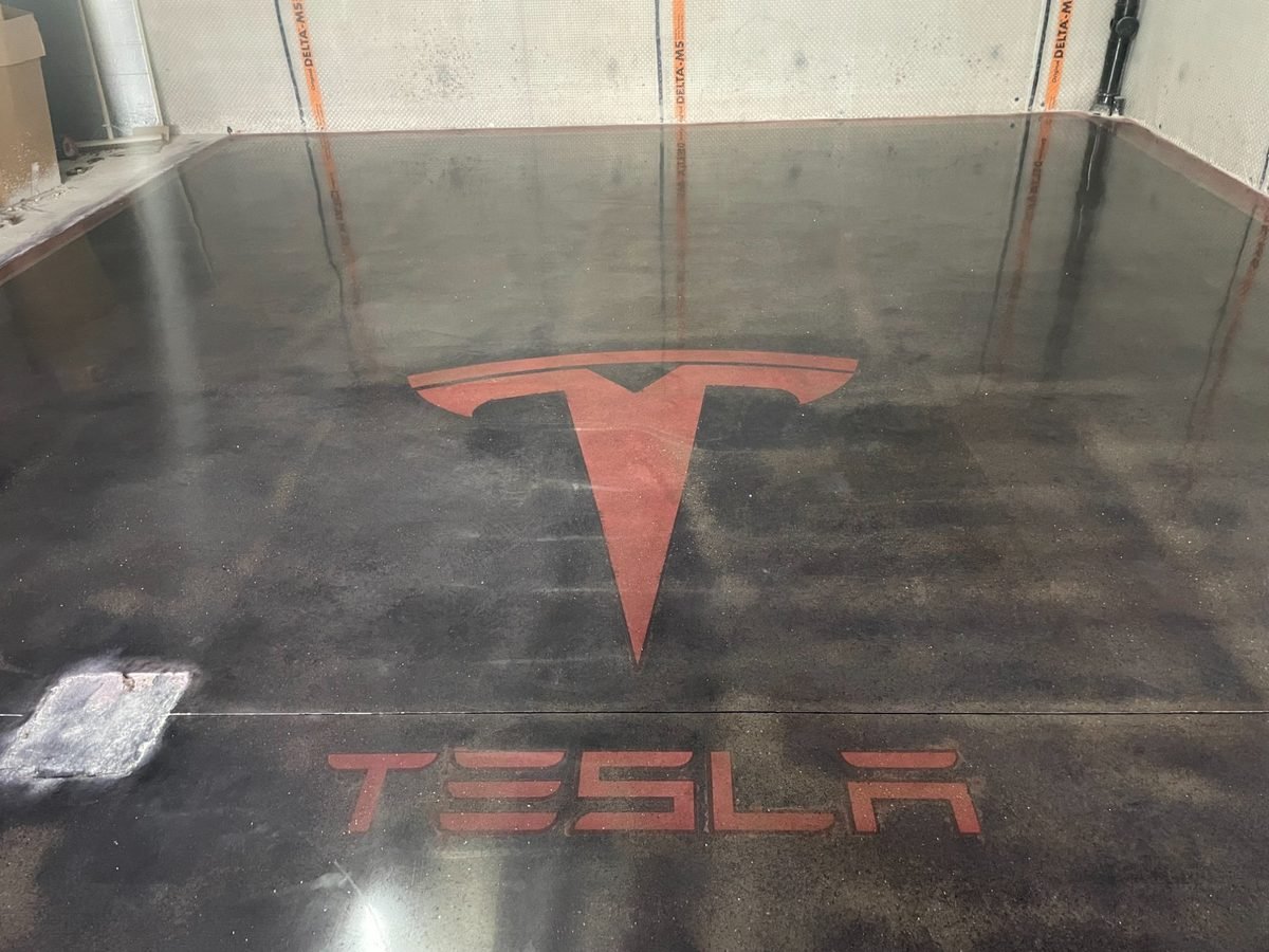 Custom stained polished concrete - Tesla logo high gloss floor inlay